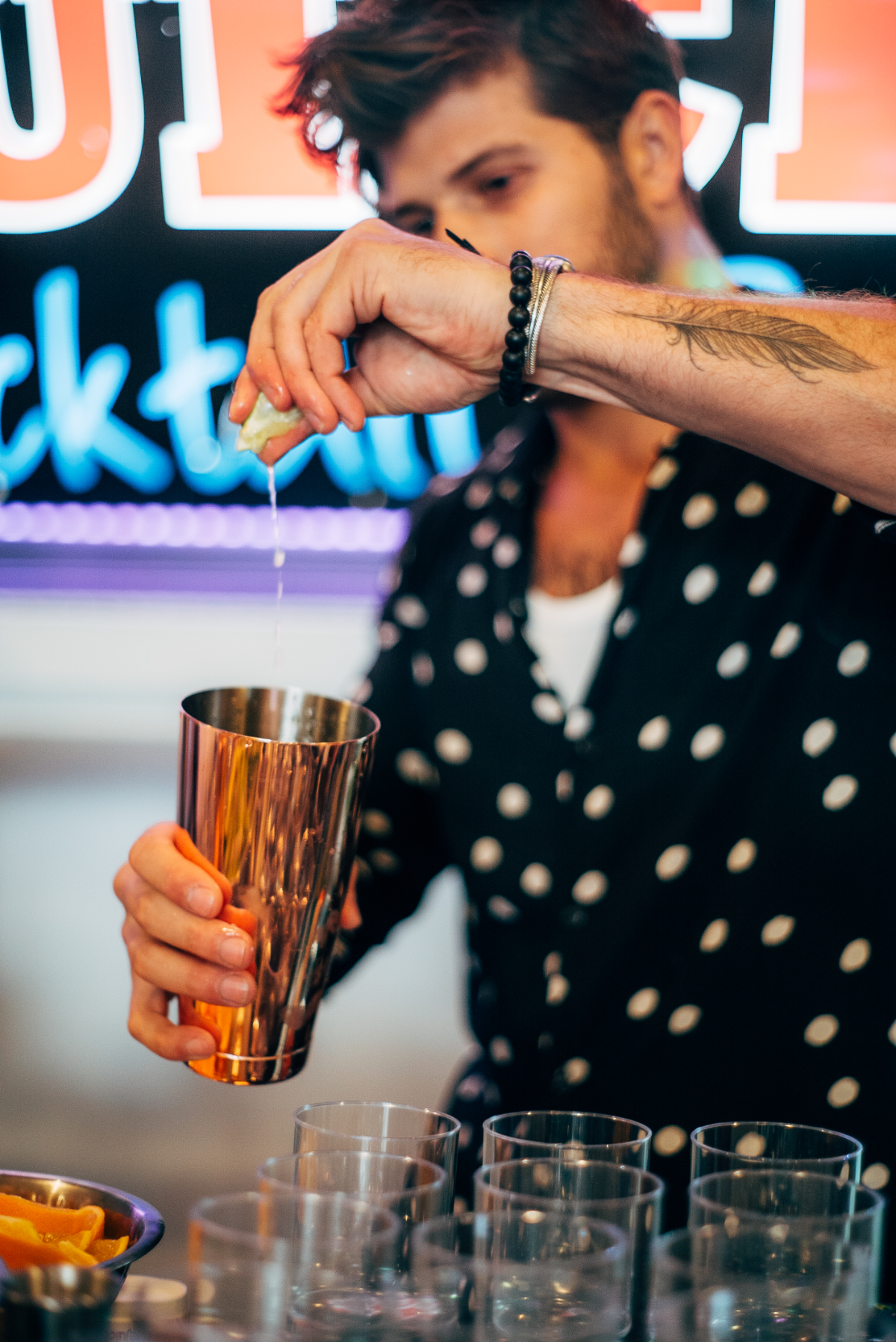 Beetle Juice bartender squeezing fresh lime into a copper shaker